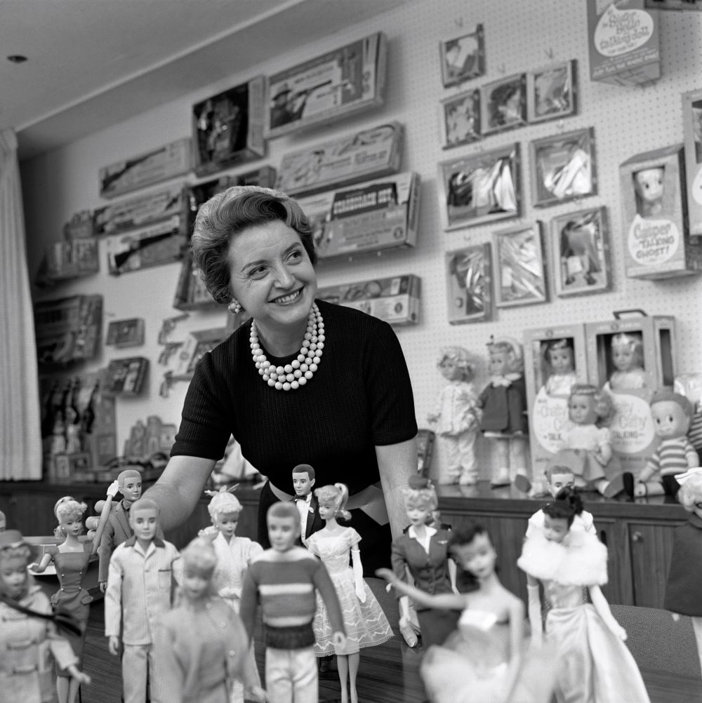 Ruth Handler, executive of Mattel Toy company, posing with collection of Barbie dolls